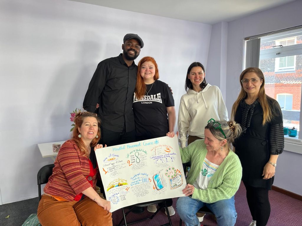 Six people receiving certificates and celebrating the end of the Mindful Movement Train the Trainer Course